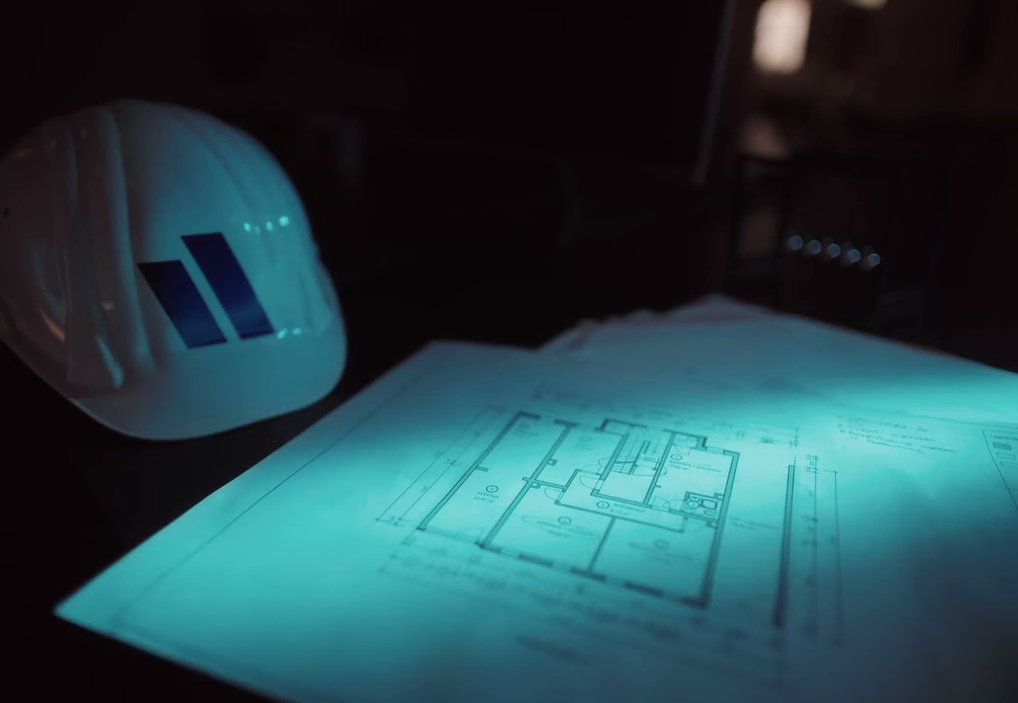 Bauhelm mit Vision-Logo auf Grundrissen